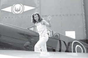 Journalist Gražina Sviderskytė next to a WW II vintage Hurricane fighter aircraft.