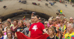 Lithuania’s Consul General in Chicago Marijus Gudynas leads his compatriots in the singing of the Lithuanian national anthem at Chicago’s popular tourist attraction – the Bean.