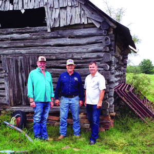 By the Lithuanian log shed: (from left) owner Delbert Derryberry, new president of the Oklahoma Lithuanian Club Jim Grego-Grigalevičius, and author Vilius Žalpys.
