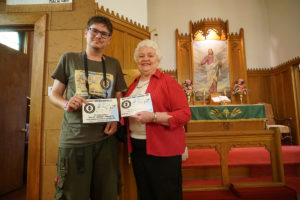 Augustinas Žemaitis presenting a certificate to church secretary Vicki Nicely stating that Jerusalem Lutheran Church is an “authentic Lithuanian heritage site.”