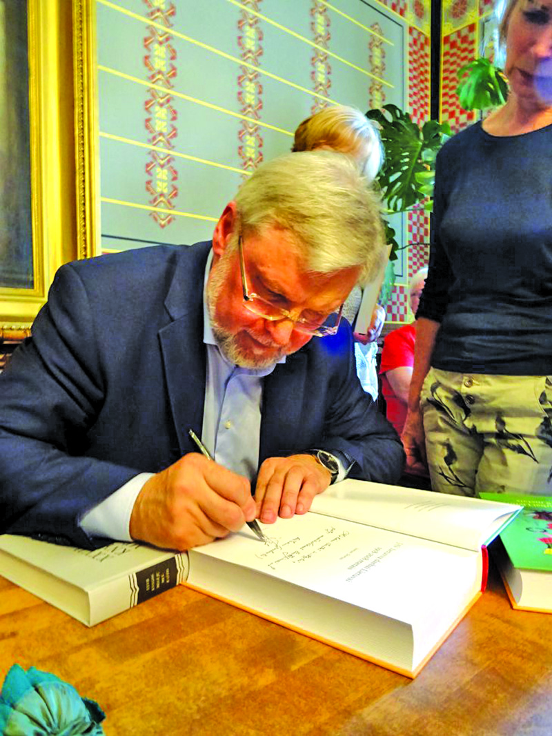 Knygos autorius profesorius Juozas Skirius pasirašinėja autografus.